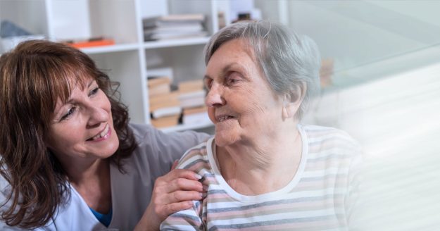 Woman at home with carer Woman is sat at home with carer