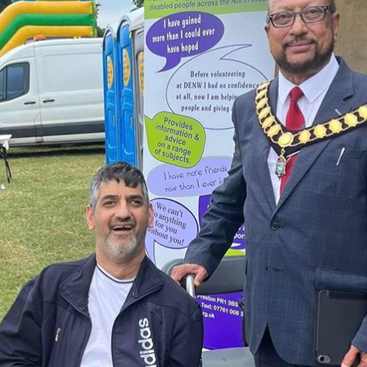 Mayor of Preston standing in front of DENW banner