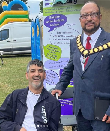 Mayor of Preston standing in front of DENW banner