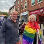 Photo of people on the Preston Pride march in a variety of outfits and flags.