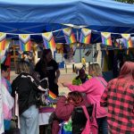 Wide shot of a busy DENW stall with lots of people.