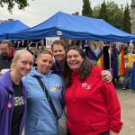 Some of the DENW team with the Preston Pride Team - all similing at the camera, including our CEO Mel Close. In the background there are blue marque coverings of stands.