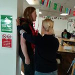 2 team members side-on stood up with a first aid in-action.